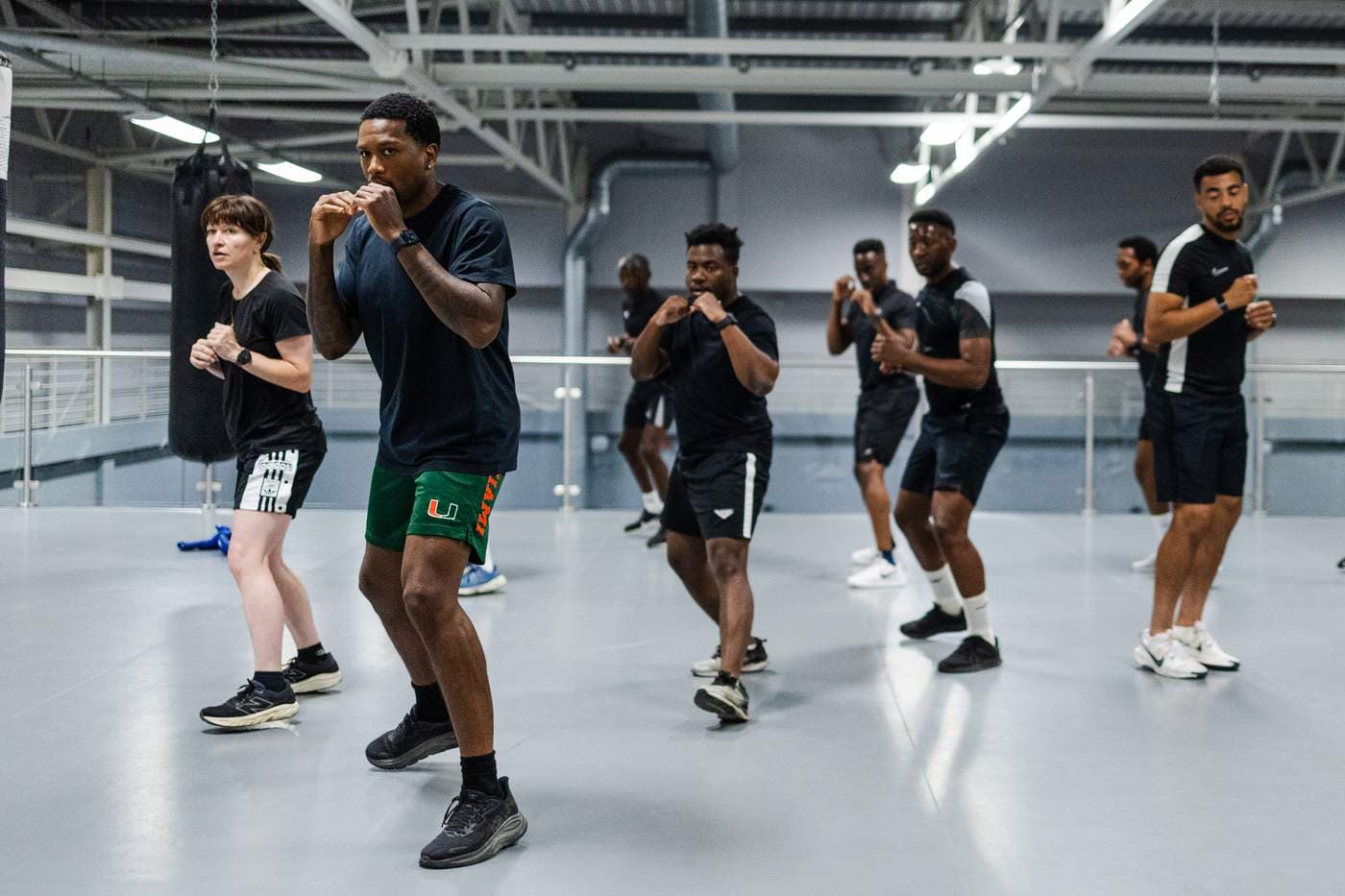 Nap leading a group through a boxing workout in a training hall